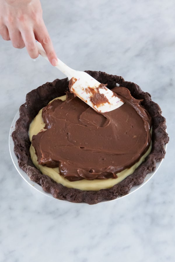 Spreading the chocolate cream layer on top of the pie.