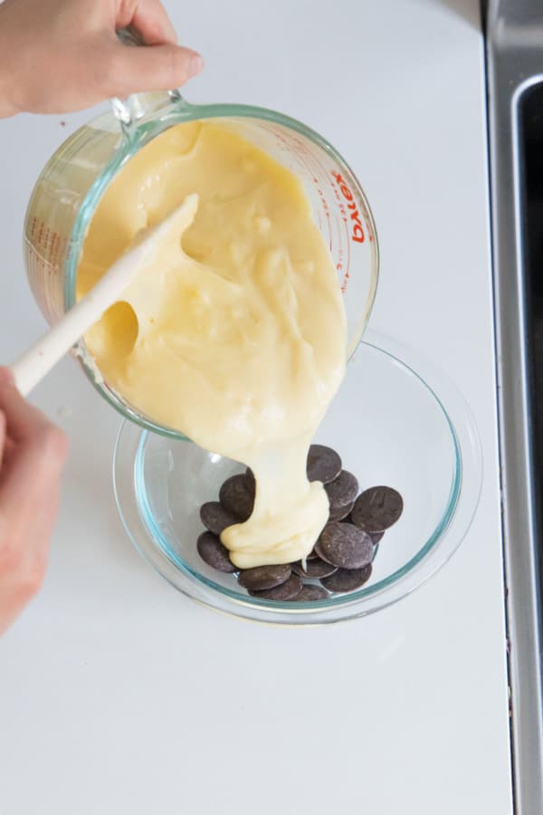 Pouring half of the warm custard with some dark chocolate to make the chocolate cream layer.