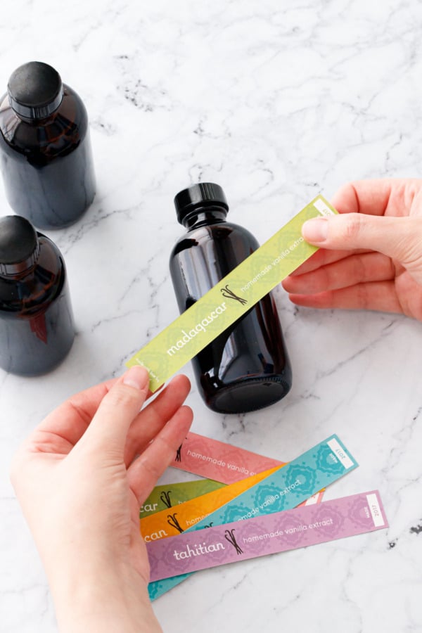 Adhering a colorful label to the final bottle of vanilla extract.