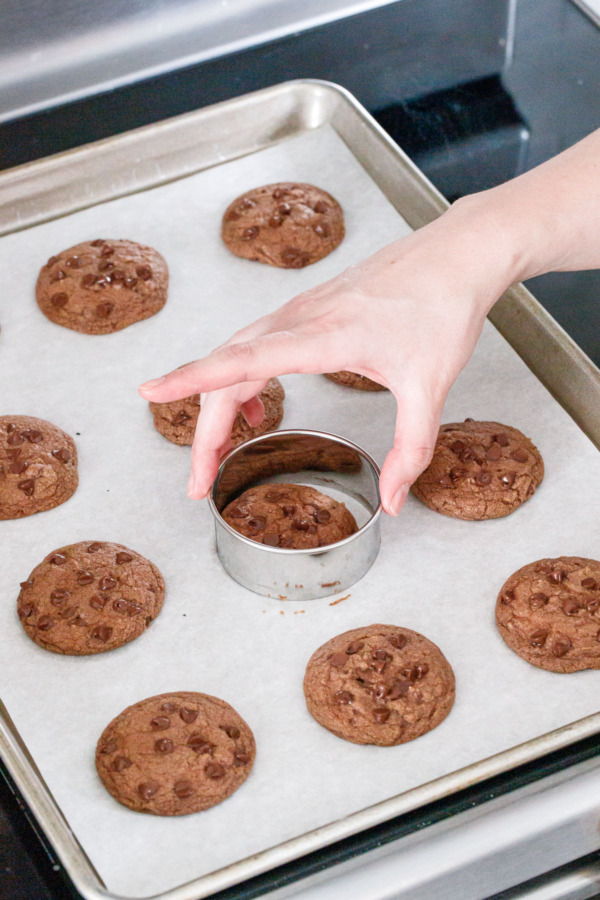 Swirling a round cookie cutter around the still-warm cookies to tighten up the round shapes.
