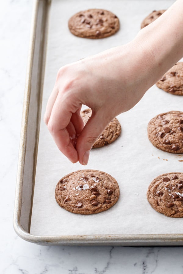 Sprinkling warm, freshly baked cookies with flake sea salt.