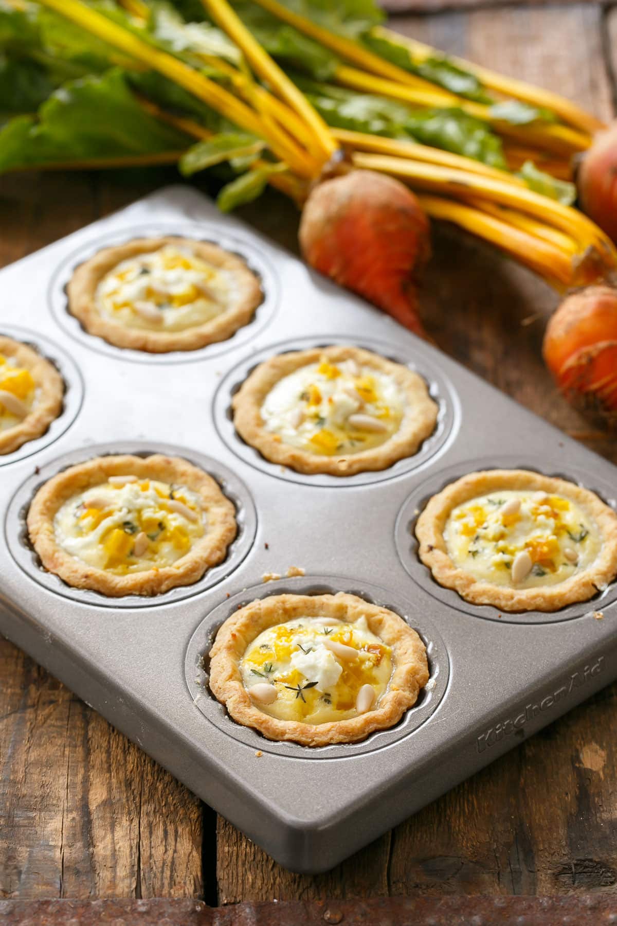 Golden Beet Mini Quiches on a rustic wood background.