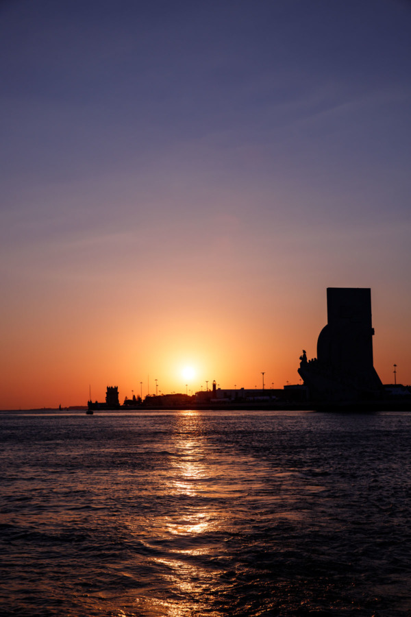 View from the river at sunset, looking back at the Padrão dos Descobrimentos and the Belém Tower in Lisbon, Portgual