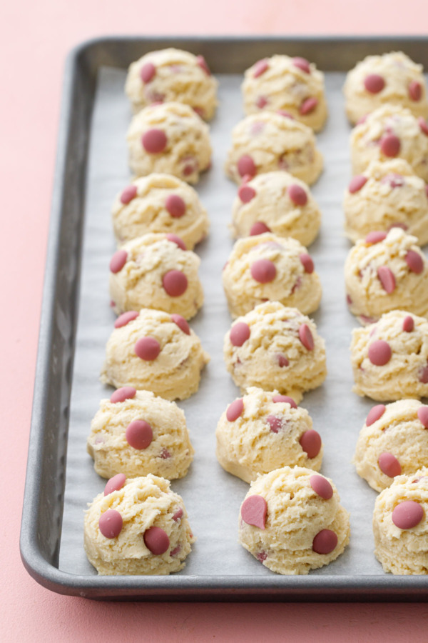 Rows of raw cookie dough balls on a cookie sheet