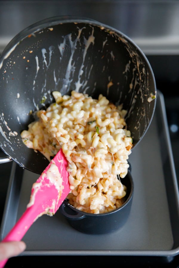 Pot of macaroni and cheese with kimchi, pouring into ramekins before baking