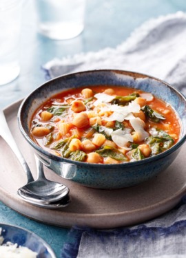 Pasta and Chickpea Stew topped with shaved pecorino, with two spoons on the side