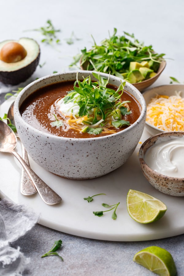 Black Bean Soup in a ceramic bowl topped with cilantro microgreens