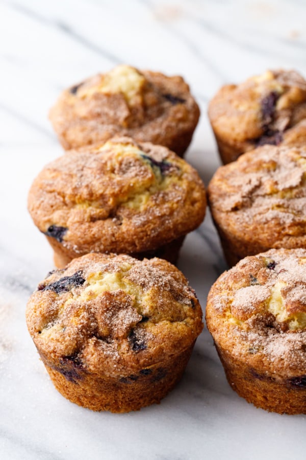 Two rows of blueberry muffins on a marble background