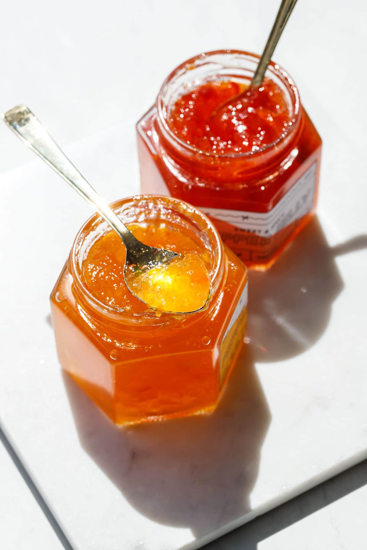 Bright sunlight making the red and orange pepper jelly sparkle