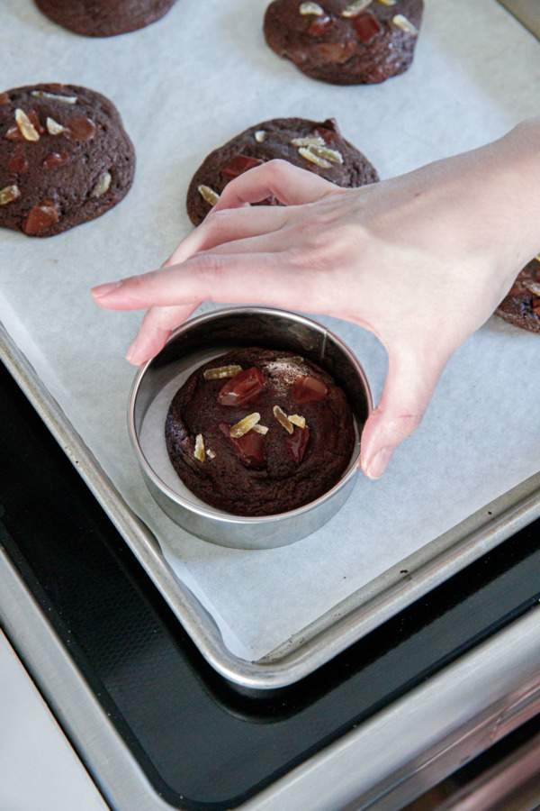 Running a cookie cutter around the edges of the cookies to make them rounder
