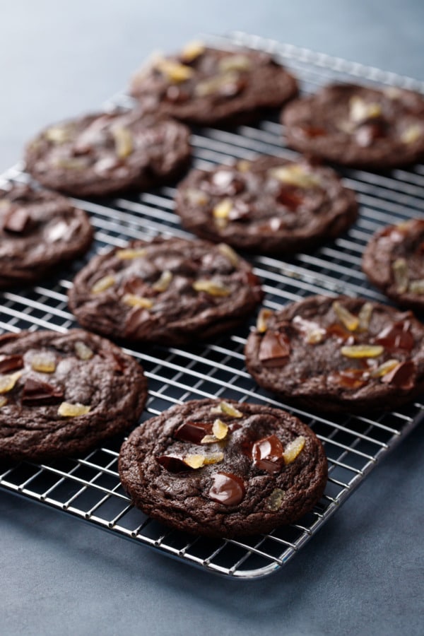Rows of Double Dark Chocolate Ginger Cookies on a wire rack on a dark blue background