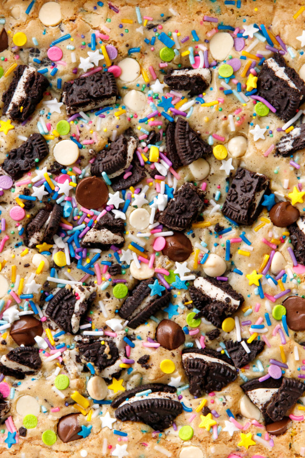 Closeup showing texture of the top of the baked blondies, with chopped cookies, sprinkles, and white and dark chocolate chips