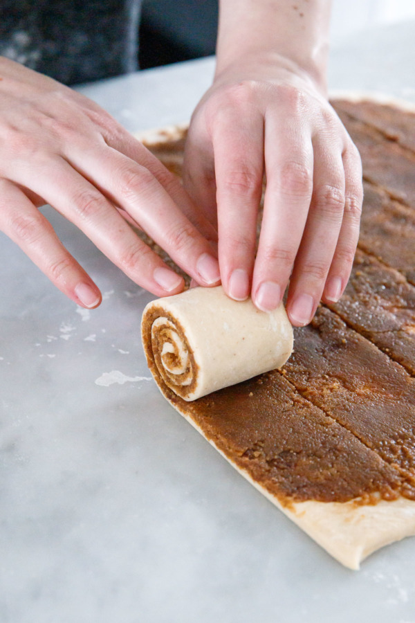 Rolling up the strips of dough into perfect cinnamon spirals.