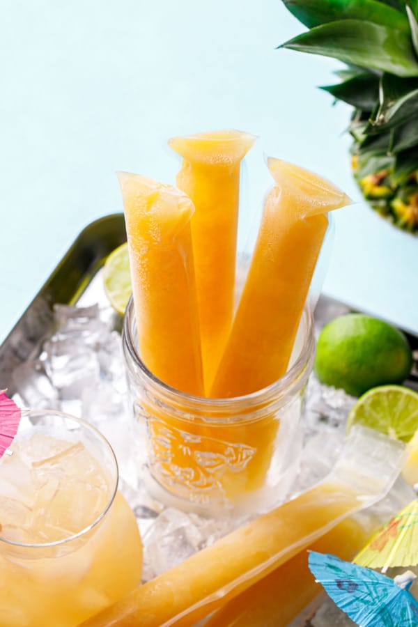 Jar with 3 Frozen Mai Tai Slushy Pops, bright orange on a light blue background.