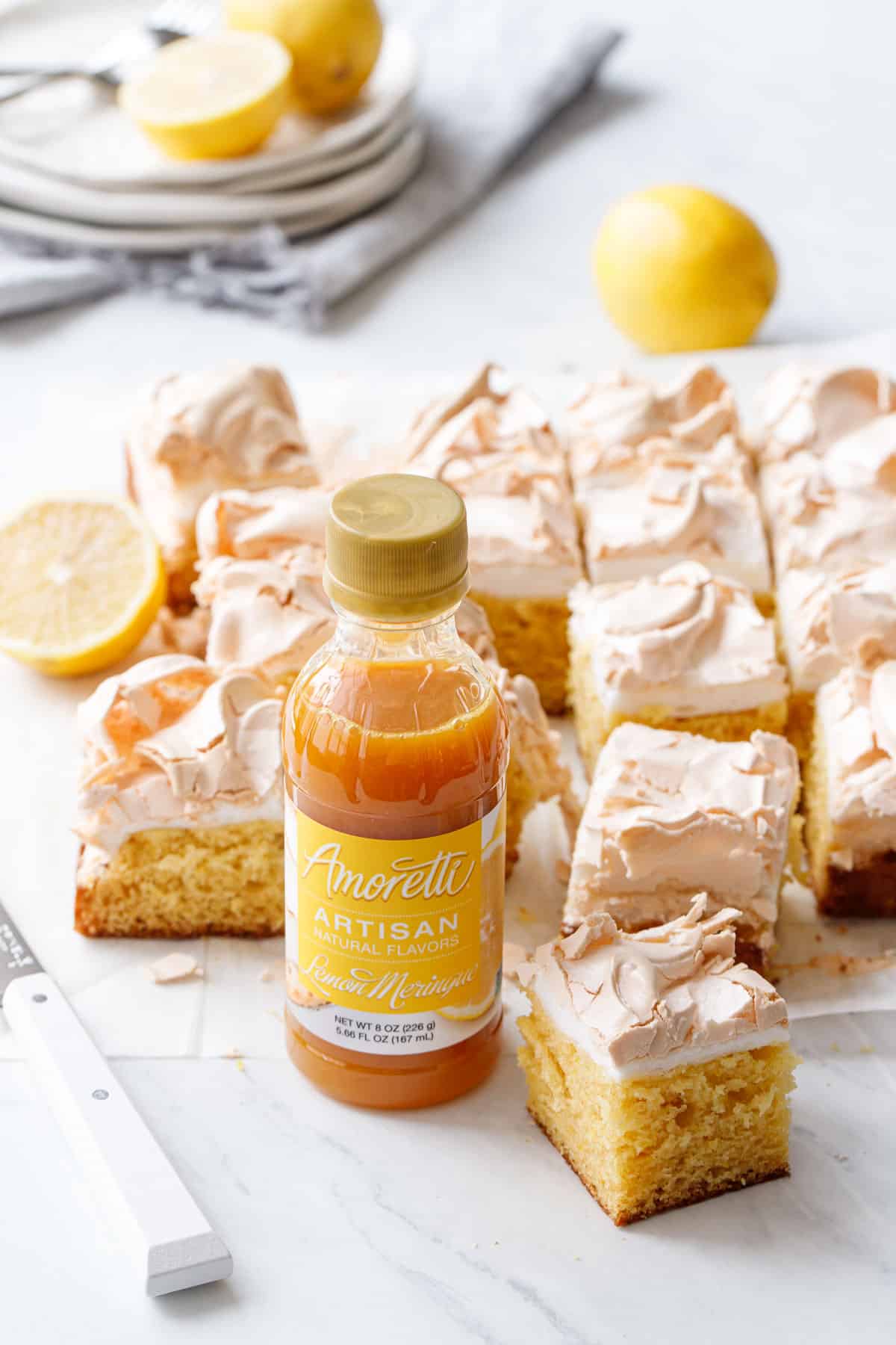 Squares of Lemon Meringue Butter Cake with a bottle of Amoretti Lemon Meringue Artisan Flavoring.