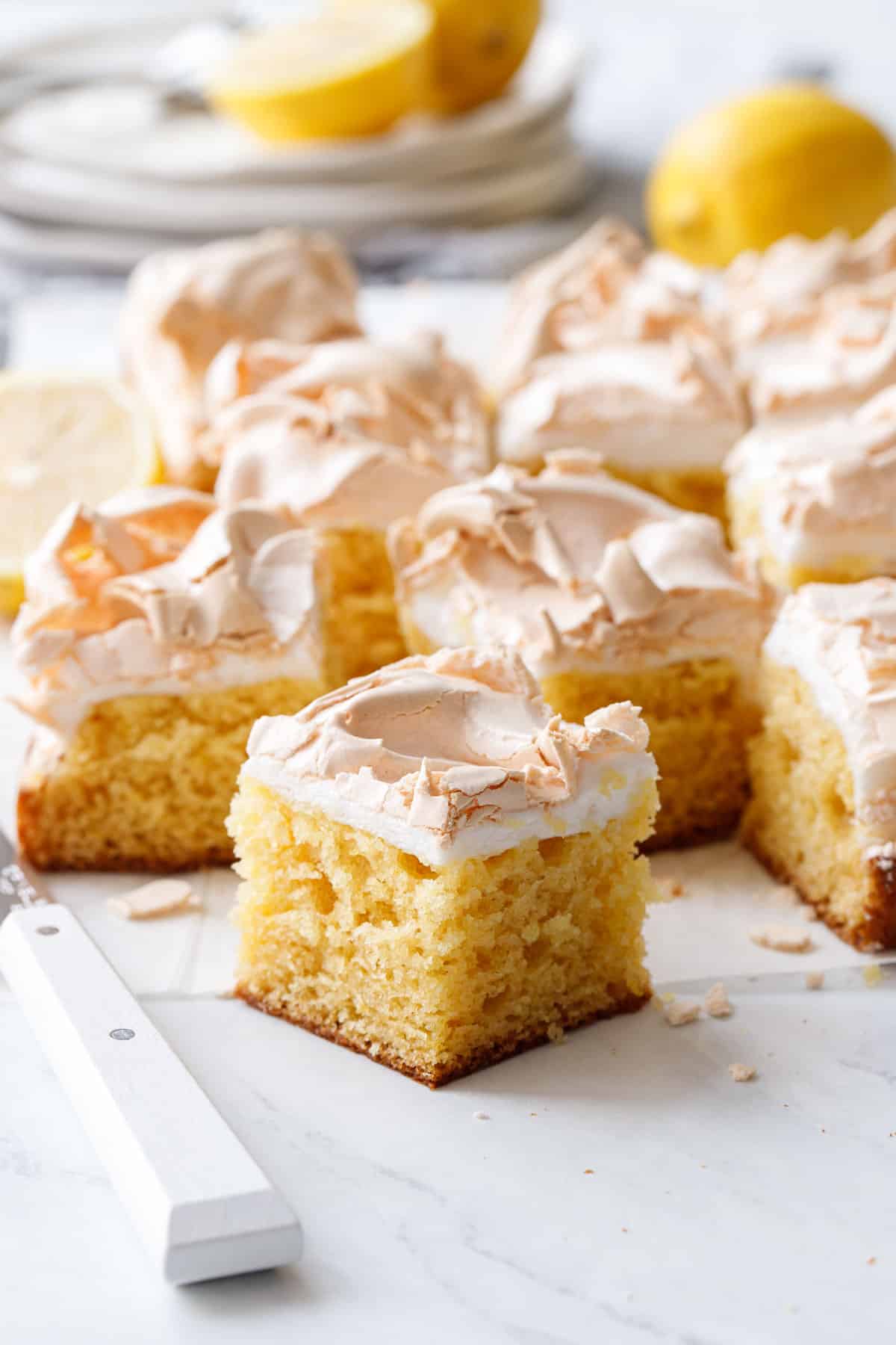 Closeup of a square of Lemon Meringue Butter Cake, showing the coarse, moist crumb and crispy toasted meringue topping.