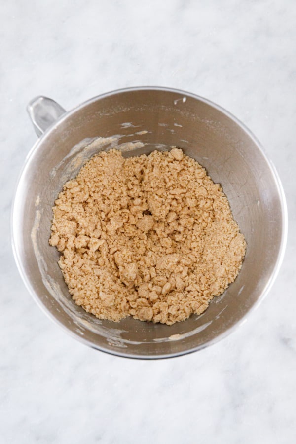 Overhead, mixing bowl after combining the first set of ingredients, butter should be broken up into pea-sized pieces.