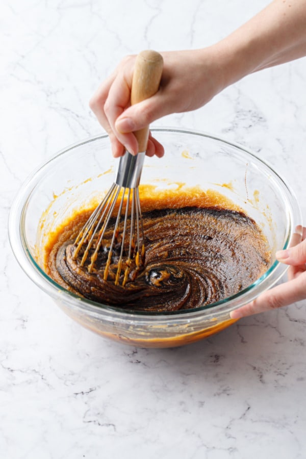 Whisking the darkly colored caramel flavoring into pumpkin batter.