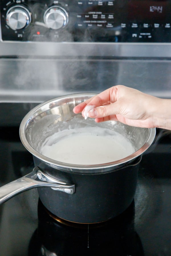 Rubbing a bit of the egg white mixture between fingertips to check for doneness.