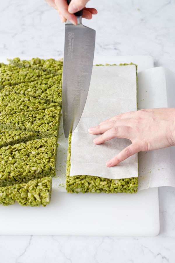 Using a parchment template to mark off even sized pieces of Matcha Rice Crispy Treats.