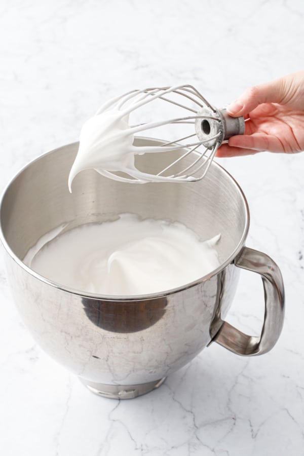 Stand mixer whisk head showing the proper stiffness of beaten egg whites (it should look like an eagle's beak).