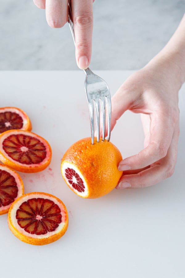 A fork marking out even intervals to serve as a guide for slicing.