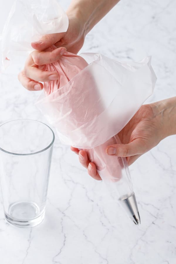 Placing one piping bag inside another bag fitted with a large 1M piping tip.
