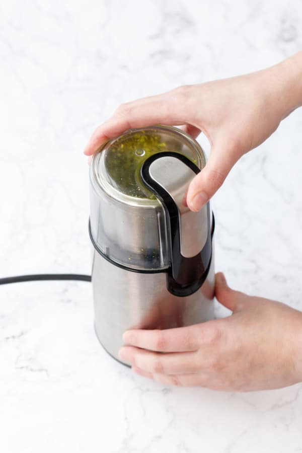 Pistachios being ground in a coffee grinder to make homemade pistachio flour.