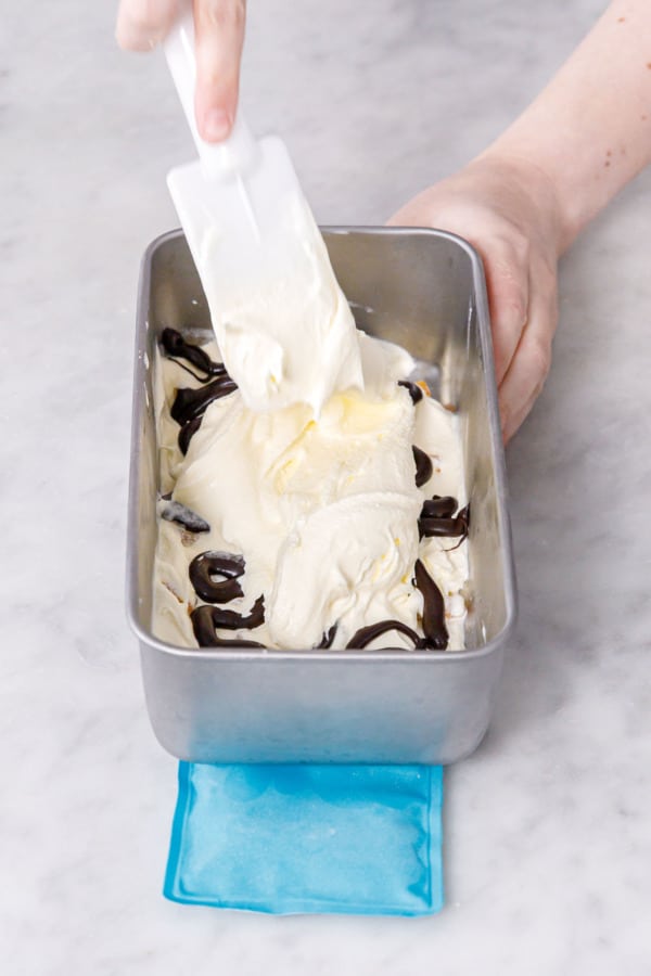 Layering the components in a metal loaf pan, starting with ice cream.