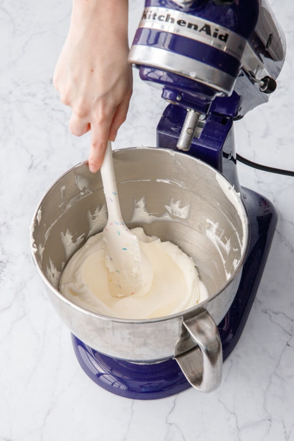 Spatula running through freshly whipped buttercream to show the light and fluffy texture.