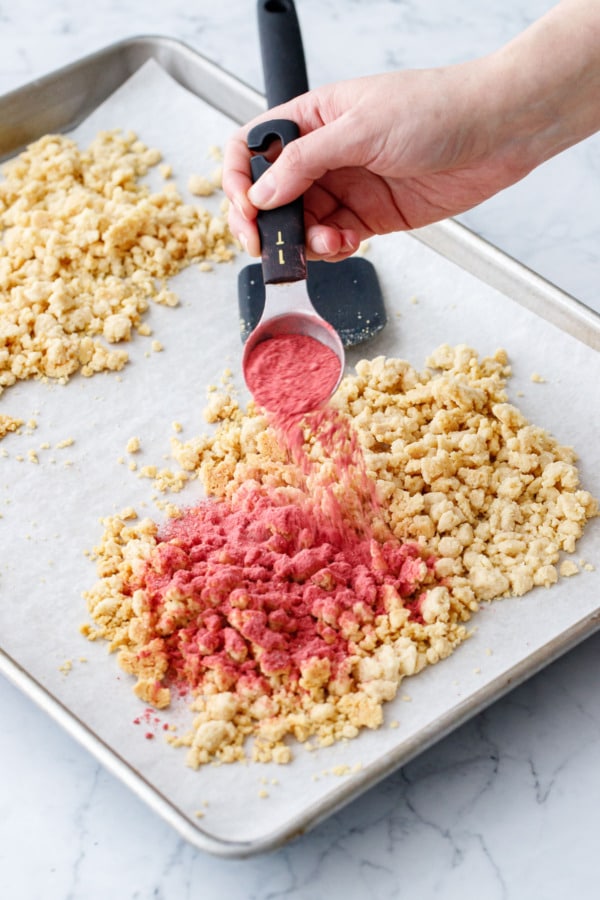 Sprinkling some of baked crumb mixture with finely ground strawberry powder.
