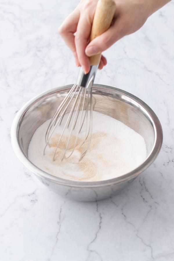 Whisking pectin into granulated sugar until evenly incorporated.