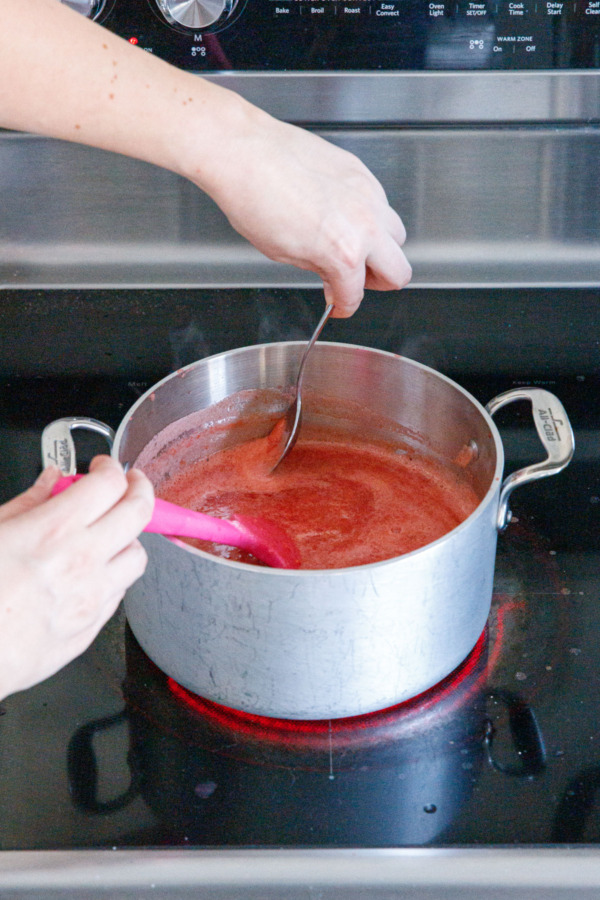 Skimming foam off the top of the boiling jam.