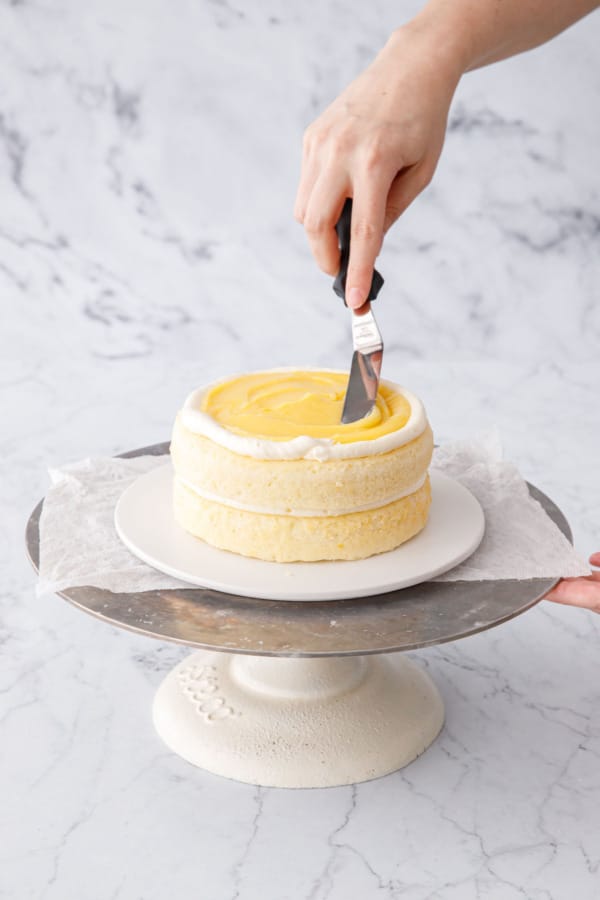 Spreading lemon curd into an even layer with an offset spatula.