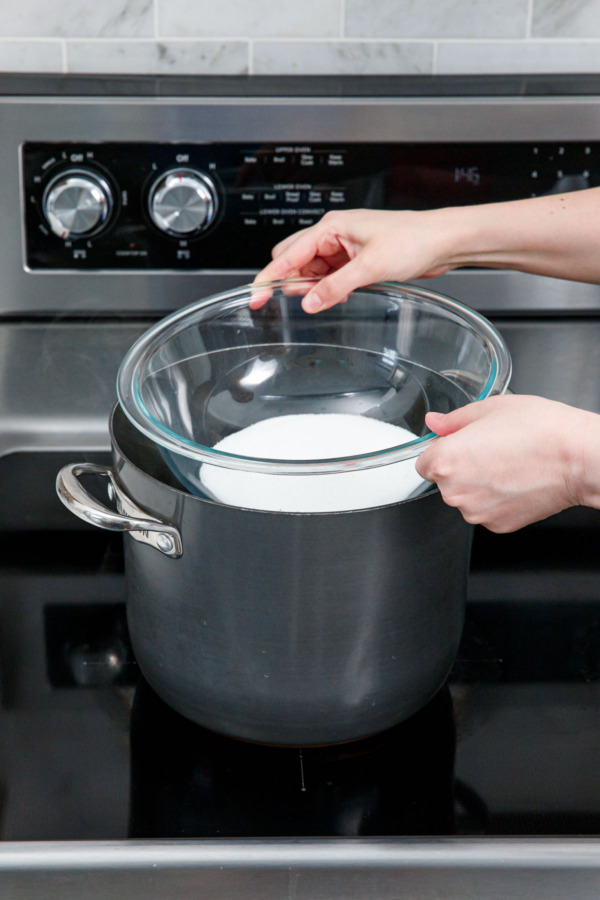 Creating a double boiler by setting a heat-proof mixing bowl on top of a large saucepan filled with 2-3 inches of water.