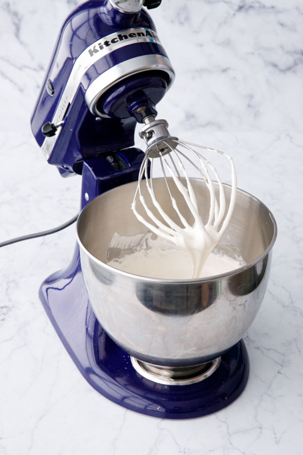 Visual example showing Swiss meringue buttercream that is too soft and almost soupy, flowing off the beater (it's much too loose to pipe).