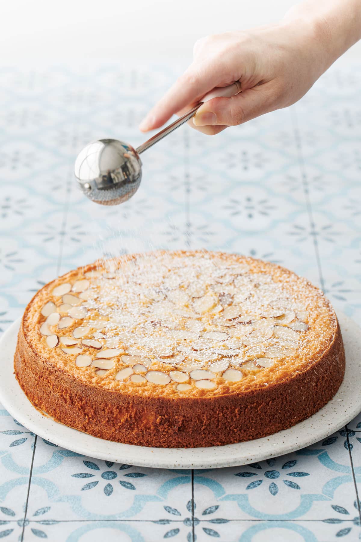 Dusting the top of the baked cake with powdered sugar before serving.