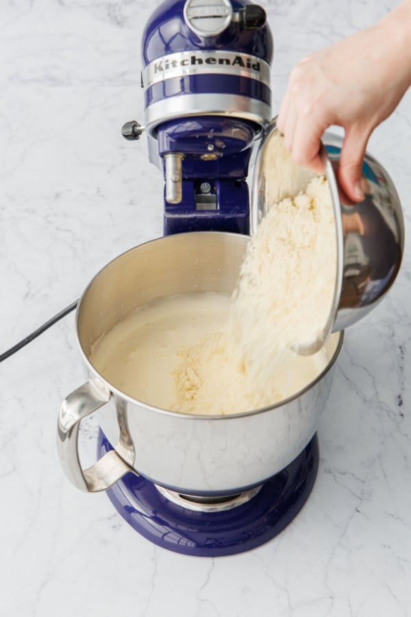 Pouring sifted almond flour into mixing bowl along with beaten egg mixture.