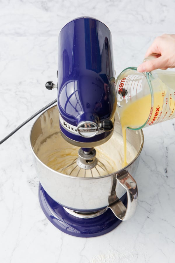 Drizzling in mostly-melted butter into a mixing bowl with the mixer running on low.