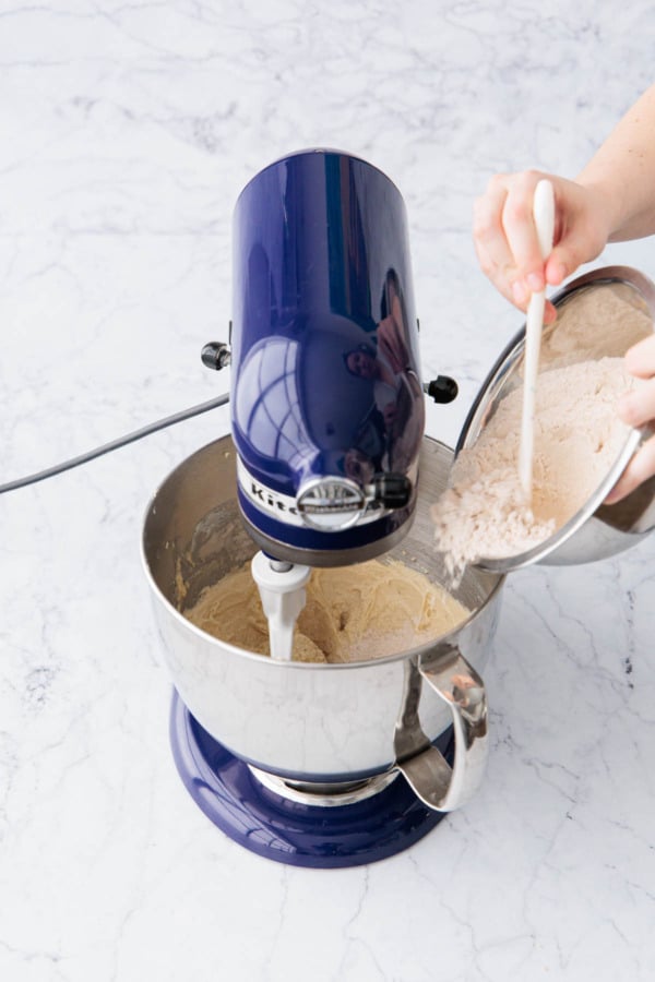 Adding half of dry ingredients to mixing bowl along with creamed butter/sugar and egg mixture.