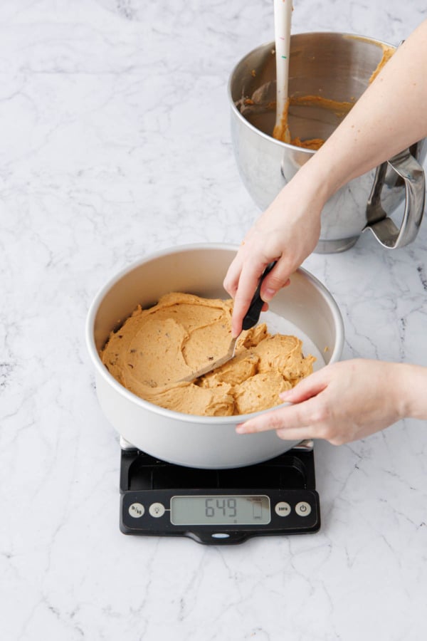 Spreading half of batter in an even layer in bottom of parchment-lined cake pan.