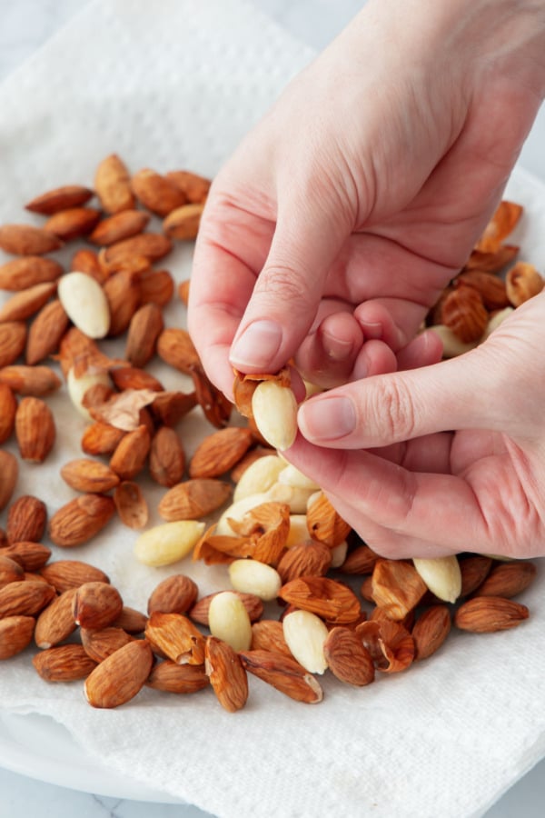 Closeup of peeling the skin off a blanched almond.