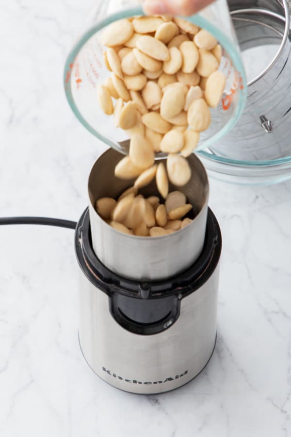 Pouring blanched (and dried) almonds in a coffee grinder.