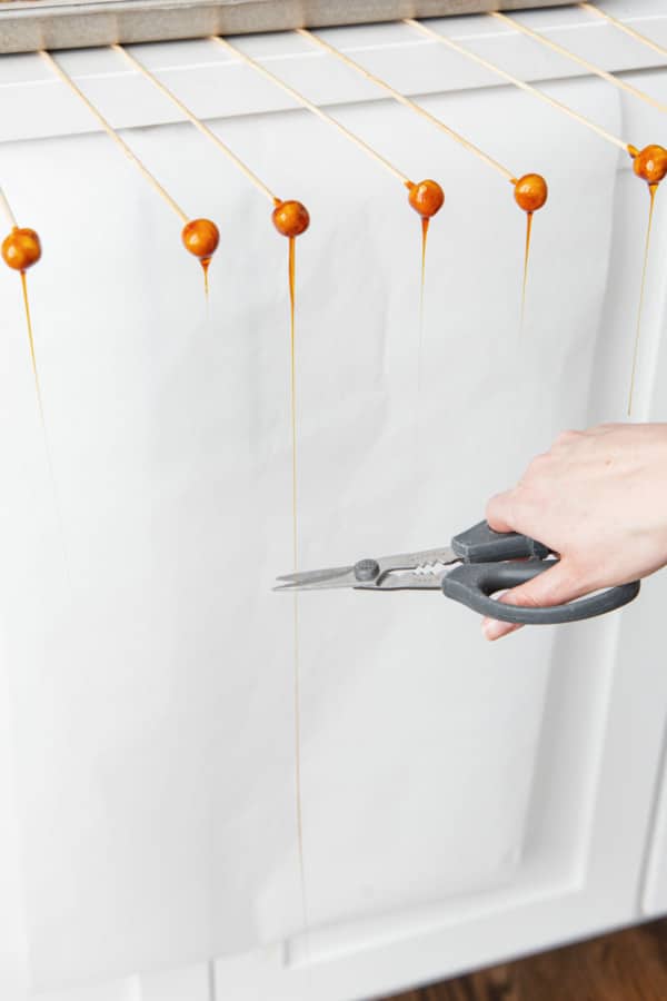 Kitchen shears cutting off the caramel drips.