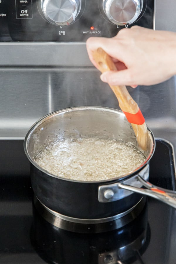Brushing down the sides of the pan with a wet pastry brush.
