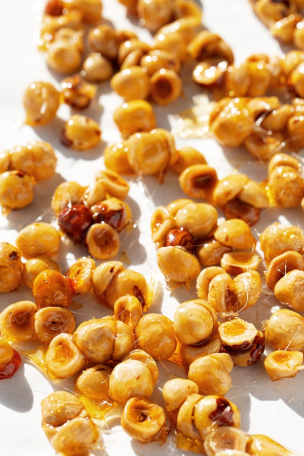 Candied hazelnut clusters cooling on a piece of parchment paper.