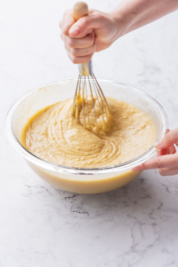 Whisking wet ingredients into dry ingredients until mostly smooth (there may still be a few small lumps).