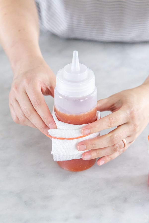 Wrapping the squeeze bottle in a paper towel to protect your hands from heat.