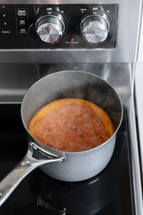 Peach candy mixture boiling on the stovetop.