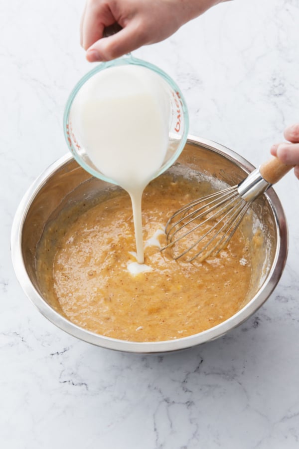 Adding half of buttermilk to banana cake batter.
